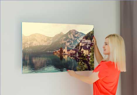 Woman putting acrylic photo prints on the wall