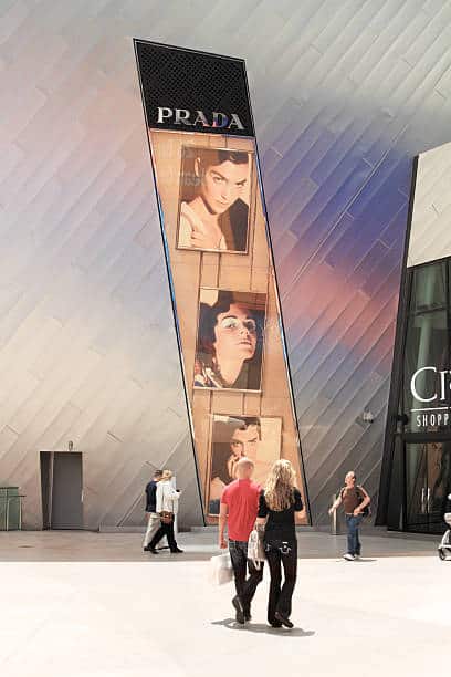 "Las Vegas, Nevada, USA - May 17, 2011: A huge Prada advertisement on the exterior wall of the City Center building on the Strip in Las Vegas advertises the store inside. Shoppers and tourists are walking near the entrance doors. The City Center complex houses upscale shops, restaurants and hotels."